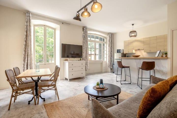 Appartement cosy avec cuisine ouverte et grandes fenêtres sur la verdure